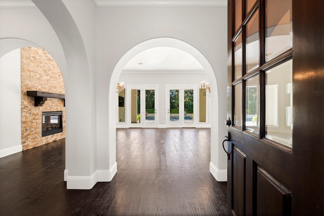 foyer entrance with a fireplace, baseboards, and dark wood-style flooring