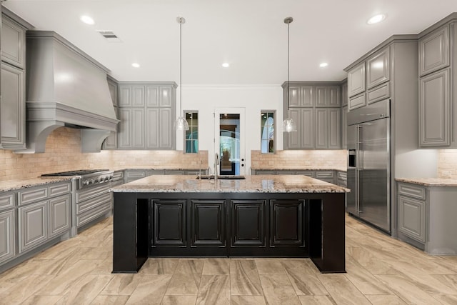 kitchen featuring gray cabinets, stainless steel appliances, a sink, and a center island with sink