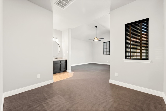 unfurnished living room featuring carpet, visible vents, baseboards, and vaulted ceiling