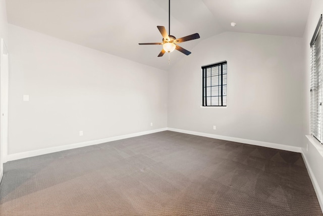 empty room featuring lofted ceiling, dark colored carpet, ceiling fan, and baseboards