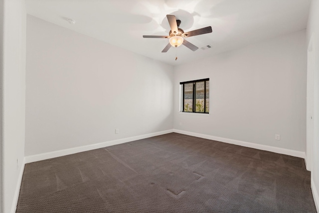 unfurnished room featuring visible vents, dark carpet, and baseboards