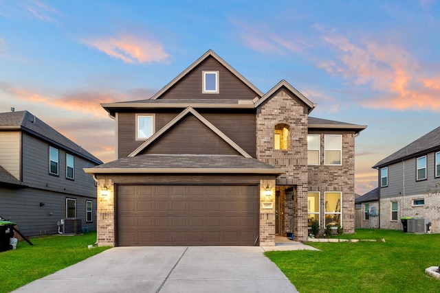 craftsman-style house featuring a yard, a garage, and central AC unit