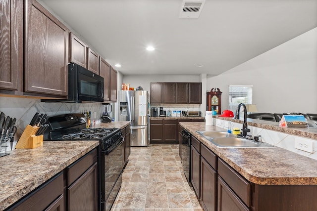 kitchen featuring sink, tasteful backsplash, dark brown cabinets, an island with sink, and black appliances