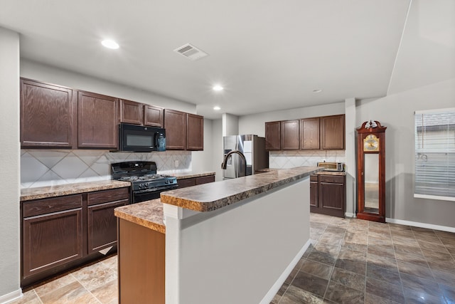 kitchen with a center island with sink, decorative backsplash, dark brown cabinetry, and black appliances