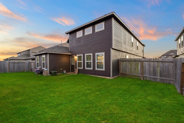 back house at dusk with a yard