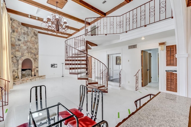 dining room with beamed ceiling, a towering ceiling, a fireplace, and a chandelier