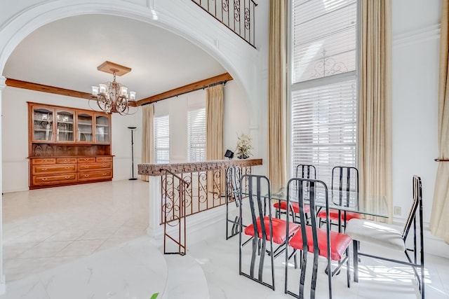 dining room with ornamental molding and an inviting chandelier