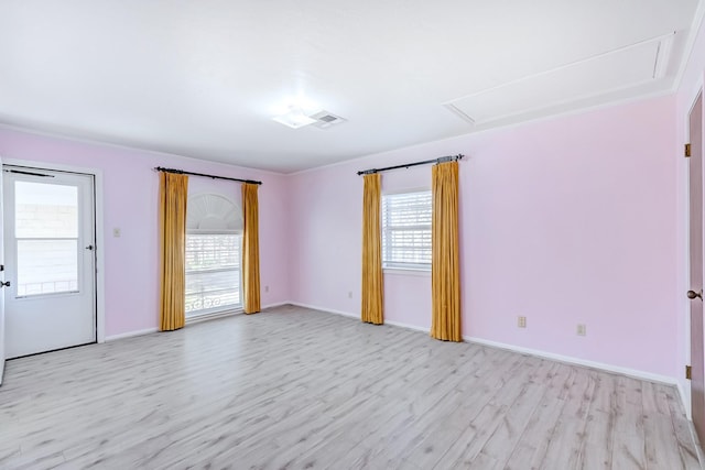 empty room featuring plenty of natural light and light hardwood / wood-style flooring