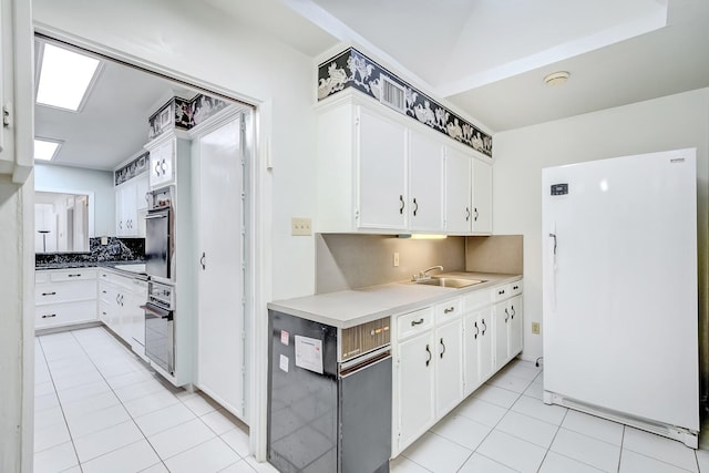 kitchen featuring white cabinetry, sink, oven, decorative backsplash, and white refrigerator