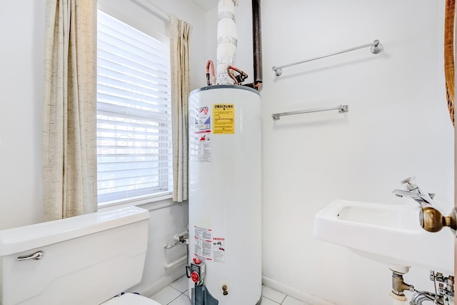 bathroom with sink, toilet, tile patterned flooring, and gas water heater