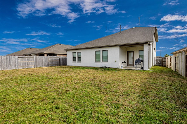 rear view of property with a yard