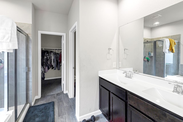 bathroom with vanity, an enclosed shower, and wood-type flooring