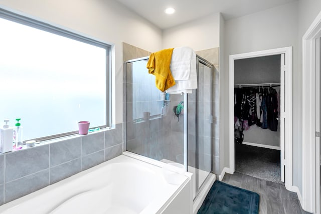 bathroom with wood-type flooring and independent shower and bath