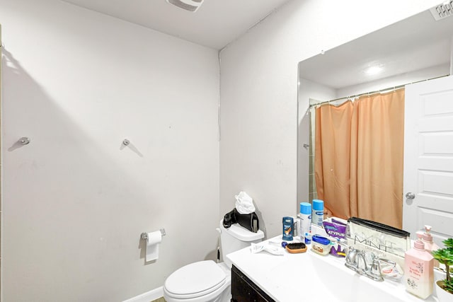 bathroom featuring vanity, curtained shower, and toilet