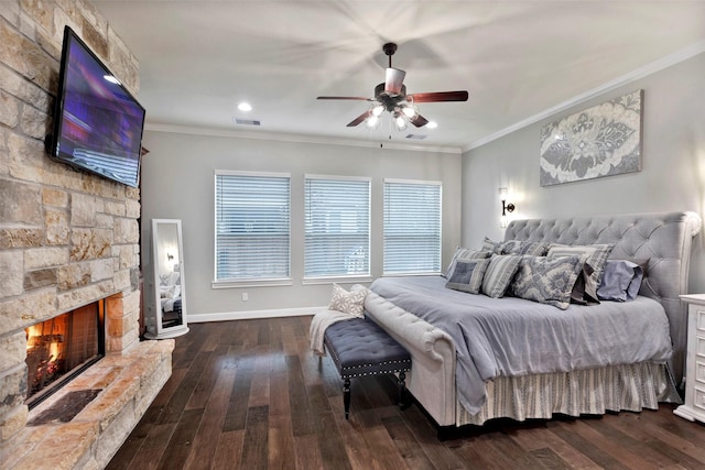 bedroom featuring a stone fireplace, ornamental molding, and dark hardwood / wood-style floors