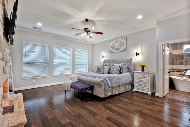 bedroom with multiple windows, crown molding, dark wood-type flooring, and a stone fireplace