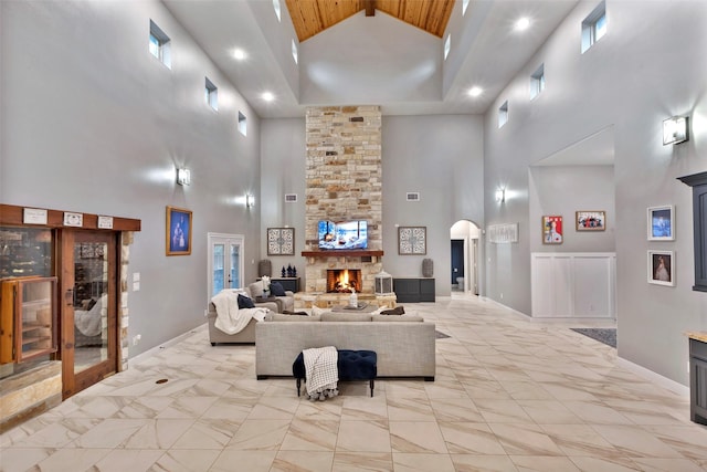 living room with a stone fireplace and high vaulted ceiling