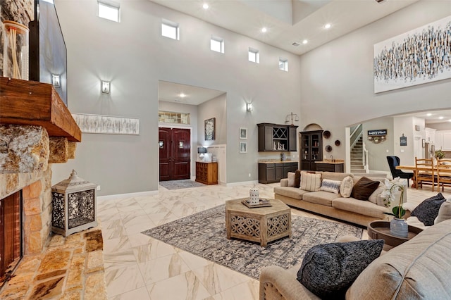 living room with a towering ceiling and a fireplace