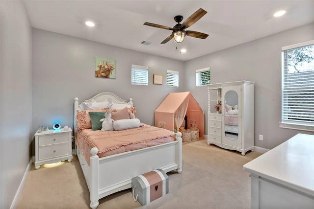 carpeted bedroom with multiple windows and ceiling fan