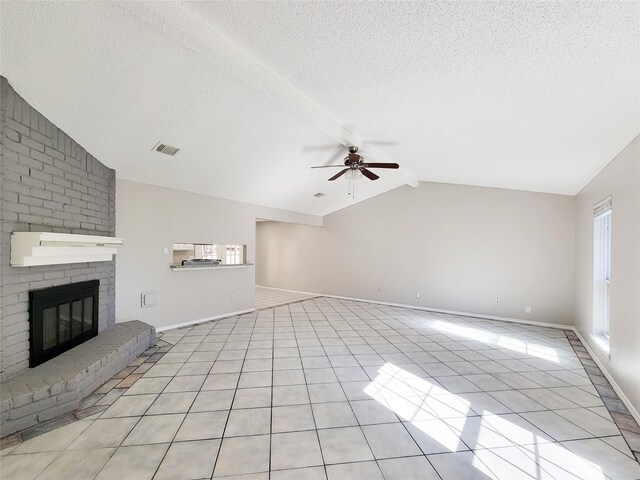 unfurnished living room with light tile patterned floors, ceiling fan, a fireplace, a textured ceiling, and vaulted ceiling