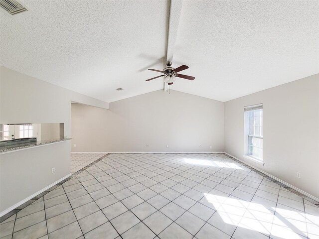 unfurnished living room featuring vaulted ceiling, light tile patterned flooring, a textured ceiling, and ceiling fan