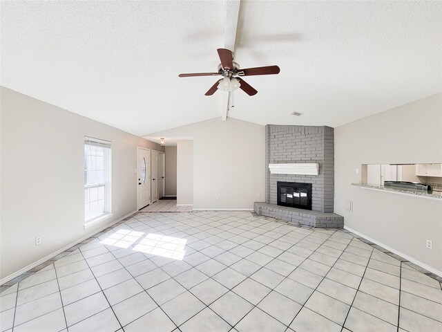 unfurnished living room featuring lofted ceiling with beams, a textured ceiling, light tile patterned floors, ceiling fan, and a fireplace