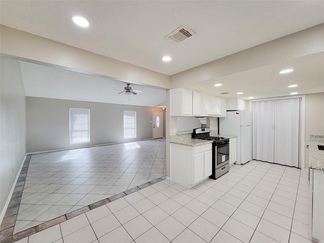 kitchen featuring light tile patterned floors, ceiling fan, white cabinetry, white refrigerator, and gas stove