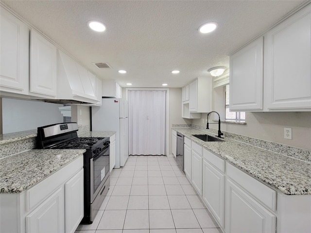 kitchen with light stone counters, appliances with stainless steel finishes, sink, and white cabinets