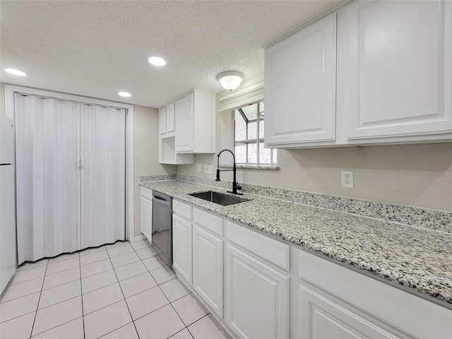 kitchen featuring sink, white cabinetry, a textured ceiling, stainless steel dishwasher, and light stone countertops