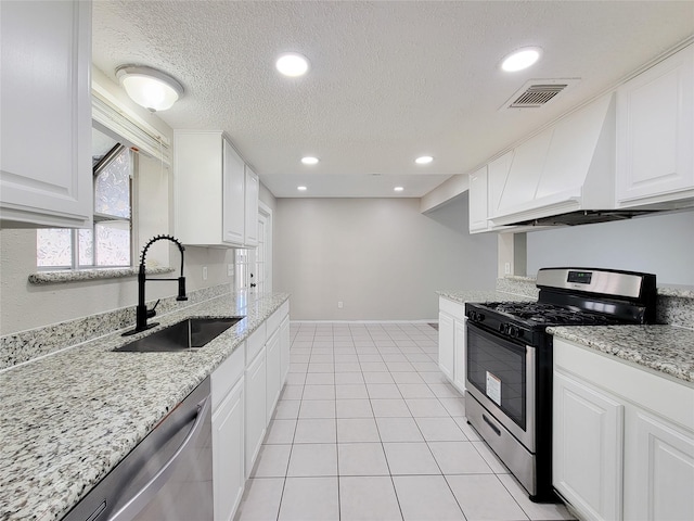 kitchen featuring sink, light tile patterned floors, stainless steel appliances, light stone counters, and white cabinets