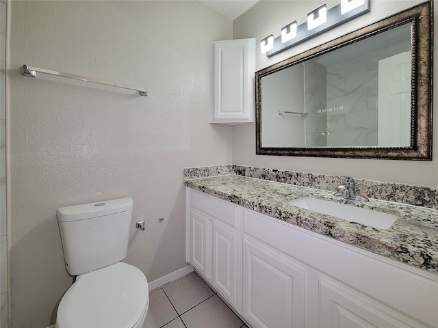 bathroom featuring vanity, tile patterned floors, and toilet