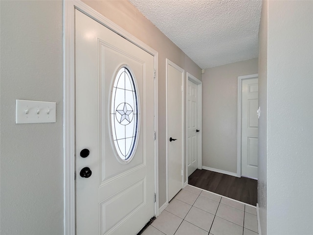 tiled entrance foyer with a textured ceiling