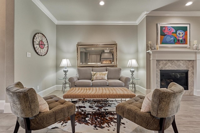 living room with a tiled fireplace, crown molding, and light hardwood / wood-style floors