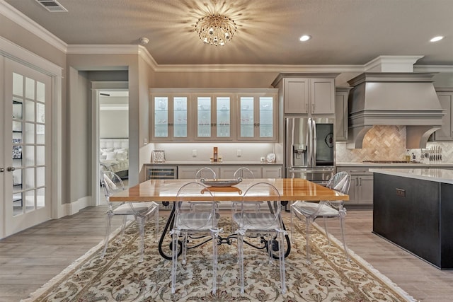 kitchen featuring gray cabinets, custom range hood, stainless steel fridge, and decorative backsplash