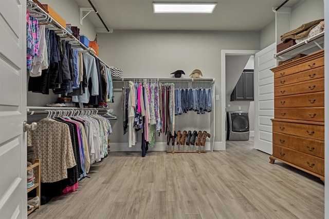 spacious closet with washer / dryer and light wood-type flooring