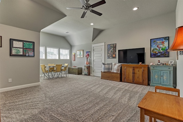 carpeted living room with ceiling fan, vaulted ceiling, and a textured ceiling