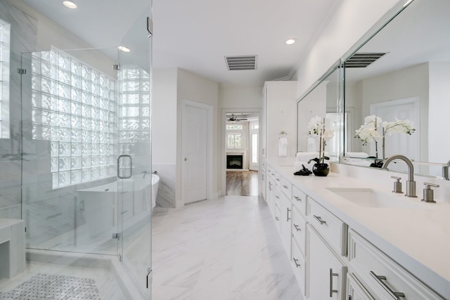 5419 W Bayshore Dr, Bacliff, TX 77518 - bathroom with a stall shower, ceiling fan, double vanity, a freestanding tub, and a fireplace