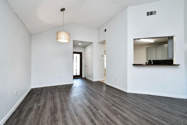 unfurnished living room with sink, dark wood-type flooring, high vaulted ceiling, and a textured ceiling