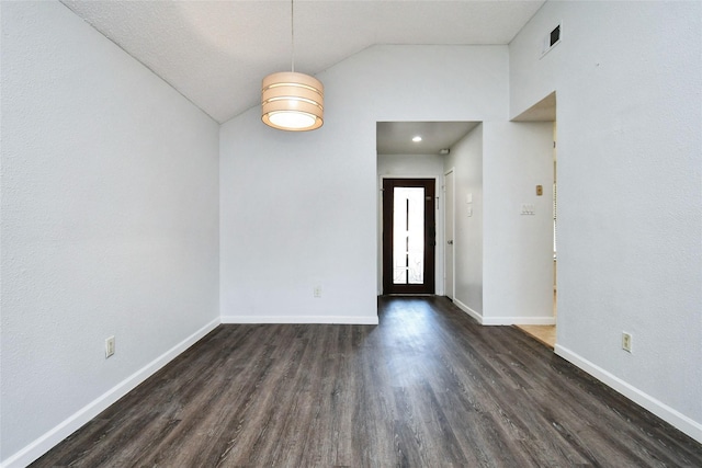 spare room featuring lofted ceiling and dark hardwood / wood-style floors