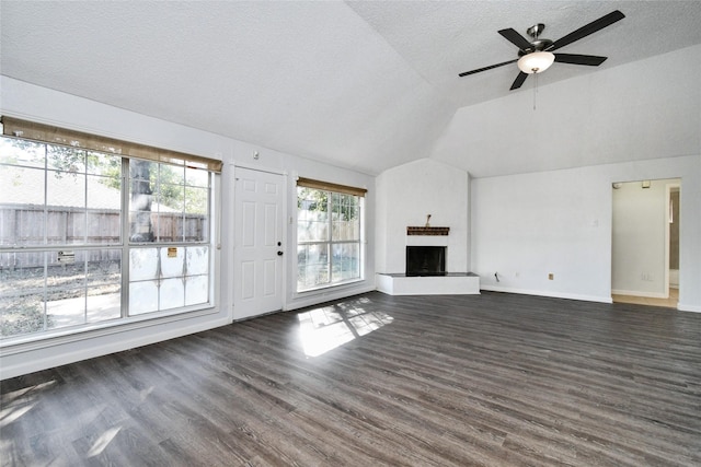 unfurnished living room with ceiling fan, dark hardwood / wood-style floors, vaulted ceiling, and a textured ceiling