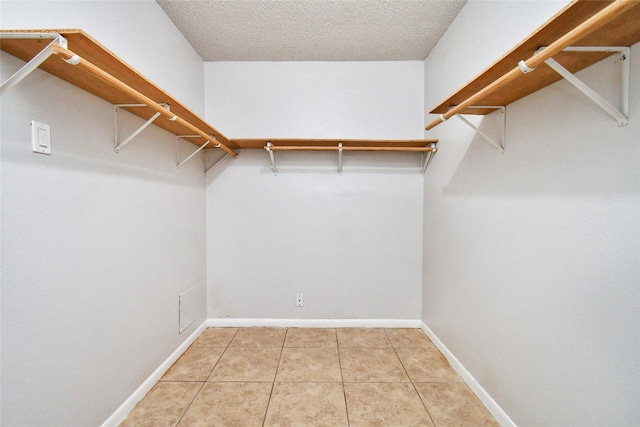 walk in closet with light tile patterned floors