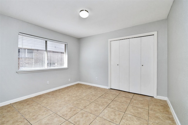 unfurnished bedroom featuring a closet and light tile patterned floors