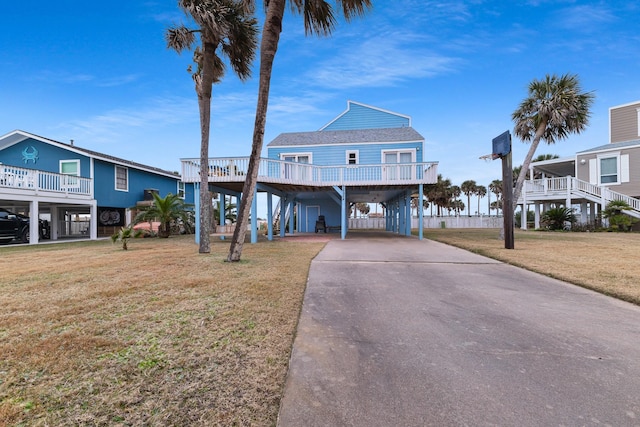 coastal inspired home with a carport and a front lawn