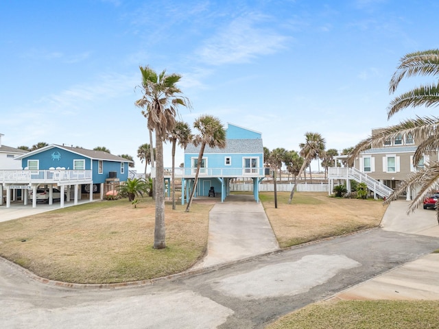 beach home featuring a front lawn and a carport