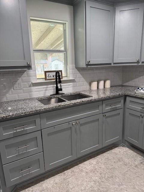 2748 Cos St, Liberty, TX 77575 - kitchen with gray cabinets, tasteful backsplash, a sink, and dark stone counters