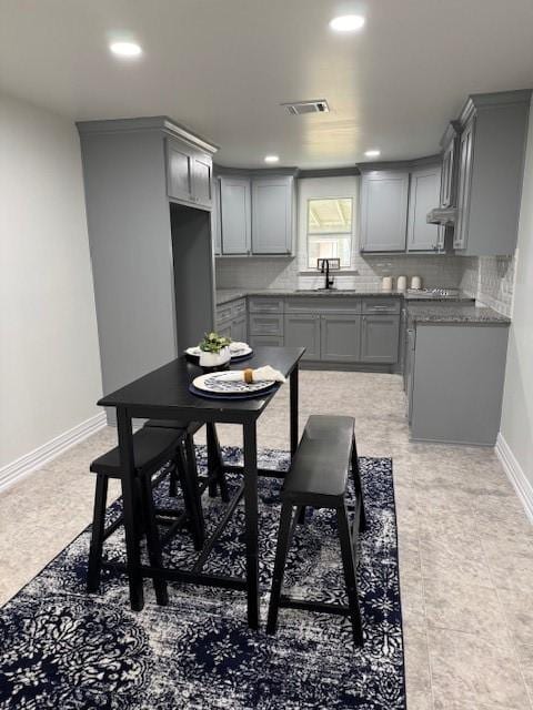 2748 Cos St, Liberty, TX 77575 - kitchen with gray cabinetry, visible vents, a sink, and tasteful backsplash