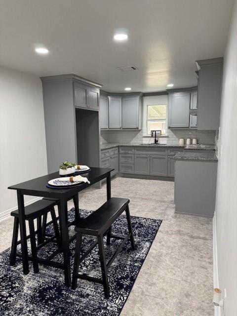 2748 Cos St, Liberty, TX 77575 - kitchen with gray cabinetry, baseboards, a sink, and backsplash