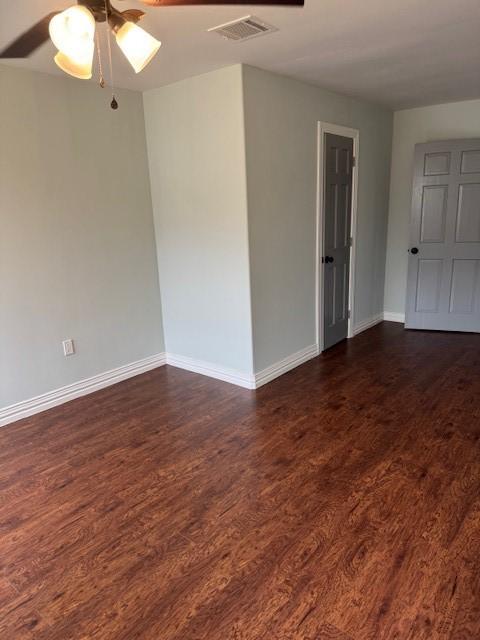 2748 Cos St, Liberty, TX 77575 - unfurnished room featuring a ceiling fan, visible vents, baseboards, and dark wood finished floors
