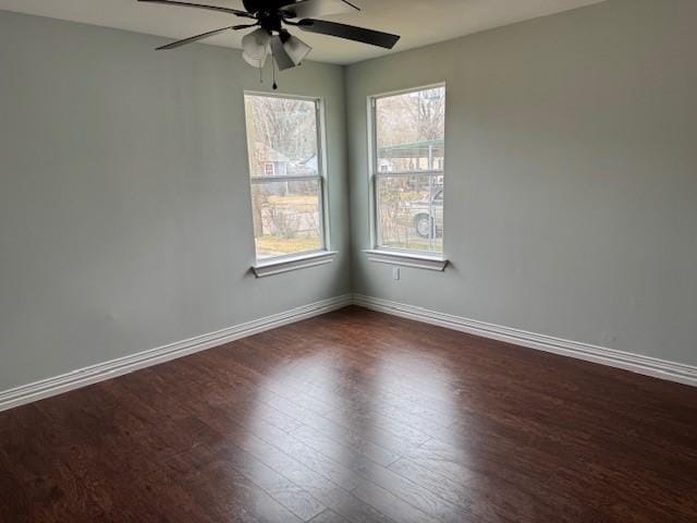 empty room with dark wood-type flooring and ceiling fan