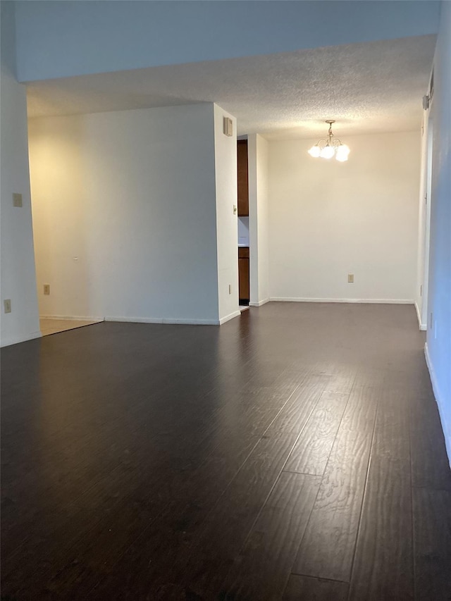 unfurnished room with dark hardwood / wood-style floors and a chandelier